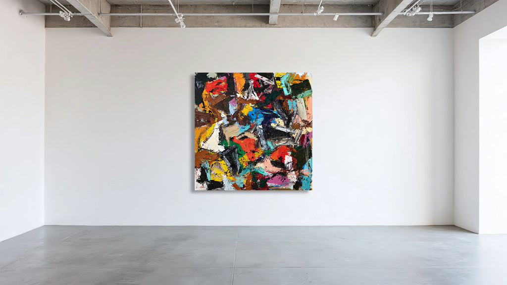A large abstract canvas painting with a vibrant mix of black, red, yellow, blue, green, and white brushstrokes, displayed on a clean white gallery wall in a minimalist art studio.